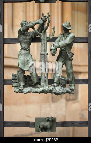 Les paysans coupent des arbres au printemps. Allégorie des saisons conçu par le sculpteur tchèque Jaroslav Horejc (1954-1957) pour le bronze de la grille décorative porte d'or de la Cathédrale Saint Vitus de Prague, en République tchèque. Banque D'Images