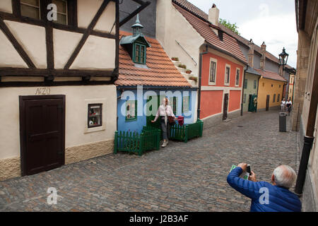 Les touristes de prendre des photos à l'aide d'un smartphone en face de la minuscule maison médiévale numéro 19 dans la ligne d'or du château de Prague à Prague, République tchèque. Banque D'Images