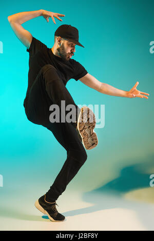 La silhouette d'un homme hip hop break dancer dancing sur fond coloré Banque D'Images