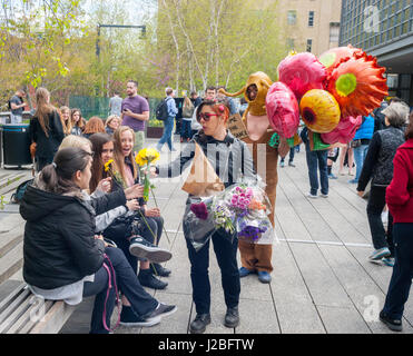 L'artiste brésilienne, André Feliciano, droite, connue sous le nom de "l'art jardinier' marche dans le parc High Line à New York assisté par le cinéaste brésilien Caru Alves, centre, le Dimanche, Avril 23, 2017 La distribution de ballons et de fleurs à passant dans sa pièce d'art performance, le Floraissance parade. Le Floraissance est un mouvement artistique créé par Feliciano basé sur l'idée que l'art contemporain ne peut pas décrire plus et nous aller de l'art dans la prochaine phase de croissance, comme des fleurs, dans le Floraissance. (© Richard B. Levine) Banque D'Images
