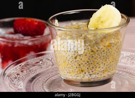 Tasse en verre de banane sains et délicieux pudding de chia. Plaque de verre décoratif dispose de refléter dans la tasse. Banque D'Images