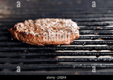 Burger de boeuf et la spatule sur le feu chaud Charbon Grill, Close-up Banque D'Images