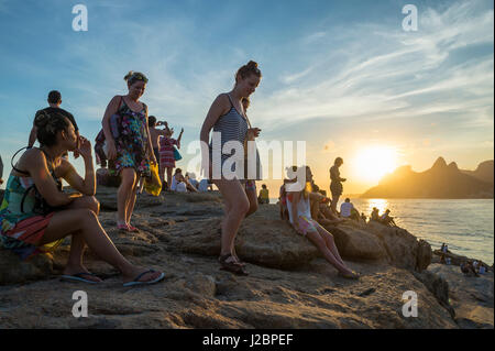 RIO DE JANEIRO - le 20 février 2017 : des foules de visiteurs affluent sur les rochers à l'Arpoador à regarder le coucher du soleil, un rituel quotidien de plus en plus populaire. Banque D'Images