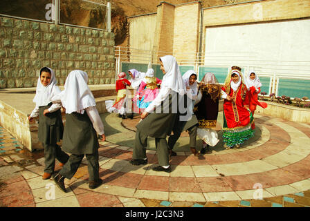 L'Iran, Téhéran, groupe de filles Dansant de joie et de sauter comme des oiseaux en costume traditionnel (MR) Banque D'Images