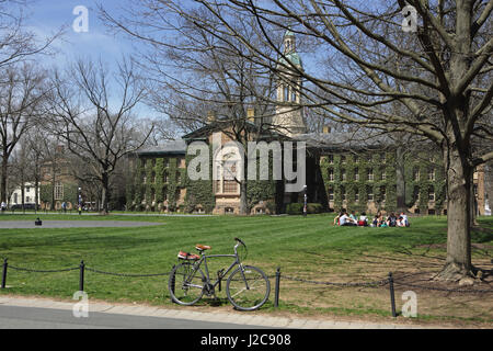 Princeton, NJ, USA - Le 11 avril 2017, Campus de l'Université de Princeton : au printemps. L'hôtel de Nassau et Cannon vert. Les élèves assis sur la pelouse lors d'une journée ensoleillée. Banque D'Images
