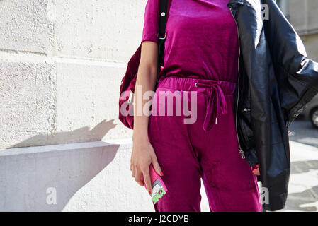 Femme en haut magenta et Track pants dans street, mid section Banque D'Images