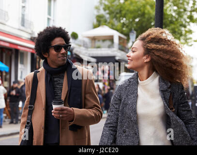 Jeune couple élégant à marcher le long de la rue de la ville Banque D'Images