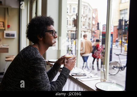 Jeune homme élégant bénéficiant d''un verre dans un café de la ville Banque D'Images