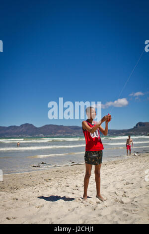 L'Afrique du Sud, Western Cape, Cape, Garden Route, autour de la ville du Cap. Un garçon quitte un cerf-volant sur la plage de Muizenberg Banque D'Images
