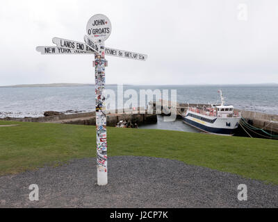 John O'Groats panneau routier avec l'Orkney Ferry dans le port derrière Banque D'Images