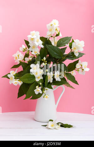 Fleurs de jasmin fraîches dans un vase sur fond de bois Banque D'Images