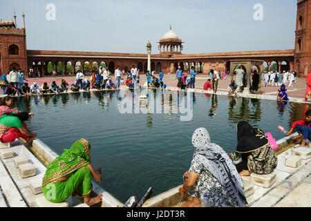 Les femmes et les hommes musulmans après la prière du vendredi dans le lavage du bassin à la mosquée Jama Masjid, Old Delhi, Inde Banque D'Images