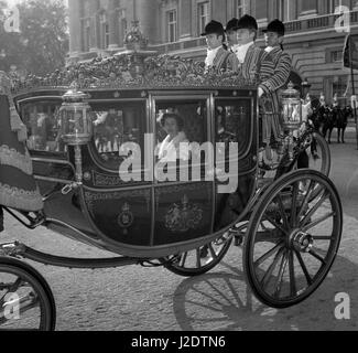 La reine Elizabeth II, portant une robe du soir de tissus d'or et un manteau de tissu argenté, voilée avec galon d'argent et bordée de vison blanc, assis dans l'Etat irlandais Coach juste avant qu'elle ne quitte le palais de Buckingham pour se rendre à Westminster pour l'ouverture du Parlement. Banque D'Images