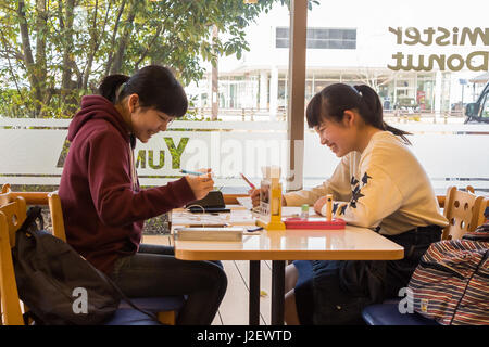 Kanazawa, JAPON - 30 mars 2017 : les filles assis à l'intérieur un Mister Donut coffee shop parlant et riant. Banque D'Images