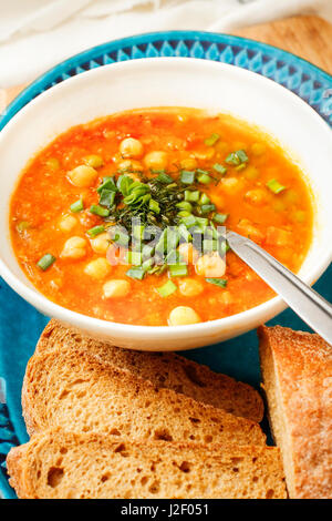 Soupe de carottes et de maïs avec du pain dans un bol blanc Banque D'Images