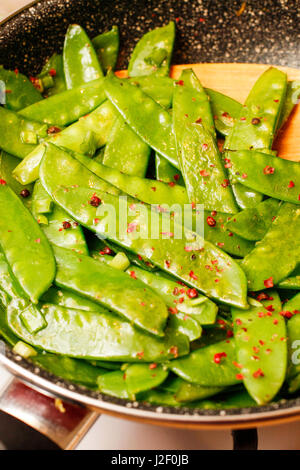 Les pois mange-tout avec des herbes et du citron en noir pan Banque D'Images