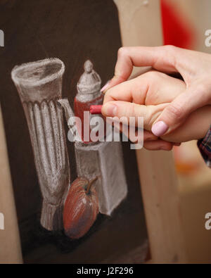 L'homme peint une vie toujours crayon pastel à l'ecole. L'enseignant aide à corriger les défauts de la photo. Mains de près. Banque D'Images