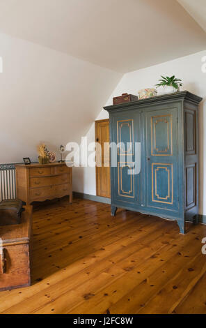 Table coffre en bois, une commode et une armoire peinte en bleu en guset chambre à l''étage sol à l'intérieur d'un vieux chalet reconstruit 1850 accueil journal style Banque D'Images