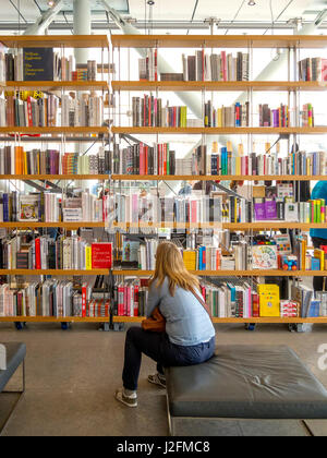 Un client parcourt une sélection de livres d'art en vente au Whitney Museum of Art de New York. Banque D'Images