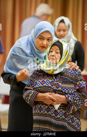 Le port d'un hijab ou foulard, une femme musulmane parle à un parent plus âgé avant les services religieux à Anaheim, CA, une mosquée. Remarque l'habillement traditionnel du Moyen-Orient. Banque D'Images