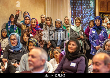 Les femmes non musulmans de la Mission locale Viejo, CA, don de la communauté le hijab, ou de la tête d'une femme musulmane traditionnelle écharpe pendant une visite d'une mosquée. Remarque musulmane paroissiens dans une tenue similaire. Banque D'Images