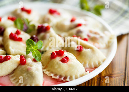 Sweet dumplings bouillis avec cerises et petits fruits sur une plaque Banque D'Images