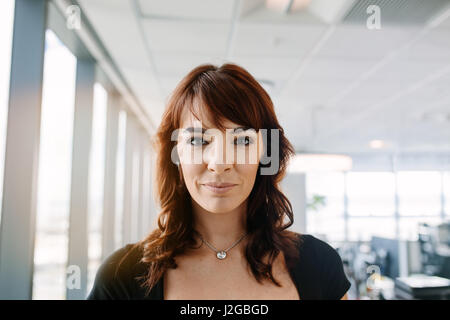 Close up portrait of beautiful young businesswoman standing in office. Les femmes de race blanche de professionnel d'entreprise. Banque D'Images