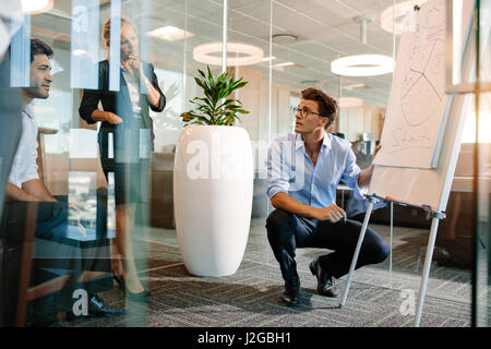 Homme mûr, fait une présentation sur un tableau-papier. Businessman explaining camembert à vos collègues lors d'une réunion. Banque D'Images