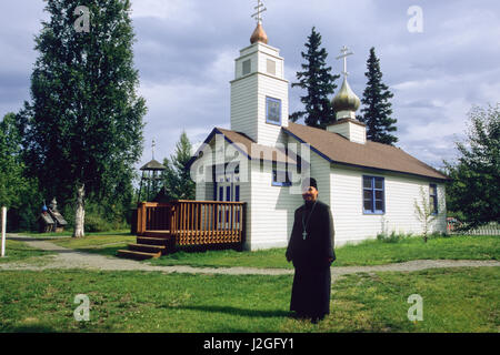 Homme d'Alaska vêtus de robes noires de la paroisse se trouve en face de l'Église orthodoxe russe Saint-nicolas à Eklutna Historical Park, situé à l'intérieur d'origine de l'Athabaskan, indiens. Eklutna Alaska Banque D'Images