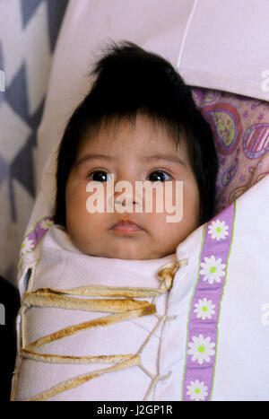 Close-up of a Native American doux bébé avec lacets à l'intérieur d'un porte-bébé traditionnel appelé un porte-bébé qui sont encore utilisées par les mères de différentes tribus d'Amérique du Nord (M.) Banque D'Images