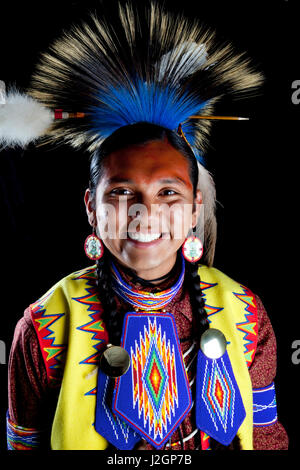 Teenage boy traditionnel habillé de pow wow regalia de perles et une coiffure roach en face de toile noire. Ian Stevens Banque D'Images