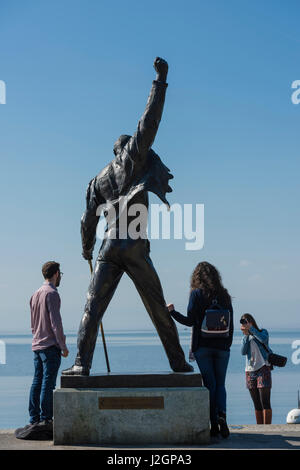 Des touristes posent pour une photo avec la statue de Freddie Mercury, fin chanteur du groupe de rock britannique Queen, au bord du lac du lac Léman à Montreux Banque D'Images