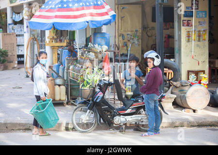 SIEM REAP, Cambodge - 6 juillet : femme de ravitaillement moto de de la bouteille traditionnelle asiatique sur station d'essence le 6 juillet 2014 au Siam Reap, Cambodge. Banque D'Images