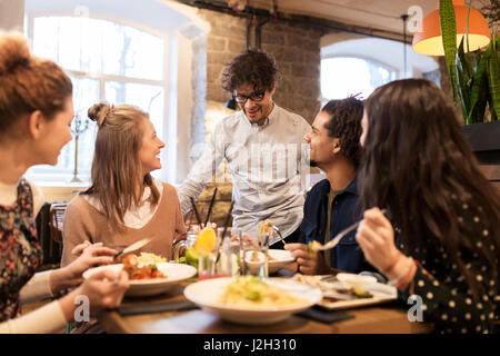 Heureux les amis boire et manger au restaurant Banque D'Images