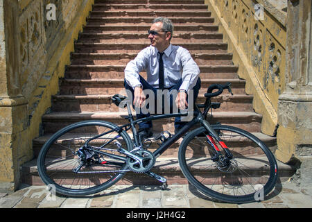 Belgrade, Serbie - Cycliste posant sur un escalier derrière son vélo Banque D'Images