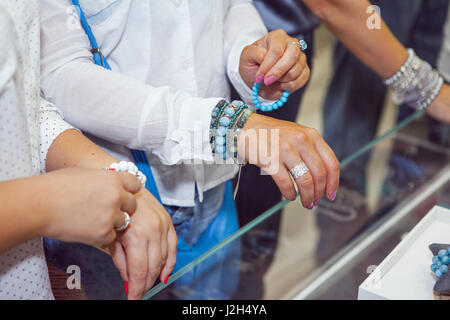 Les femmes tentent de bracelets et de bijoux dans un magasin de bijoux Banque D'Images