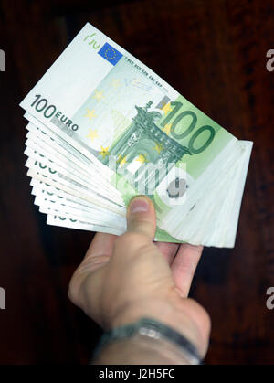 Une main tenant 100 billets en euros Banque D'Images