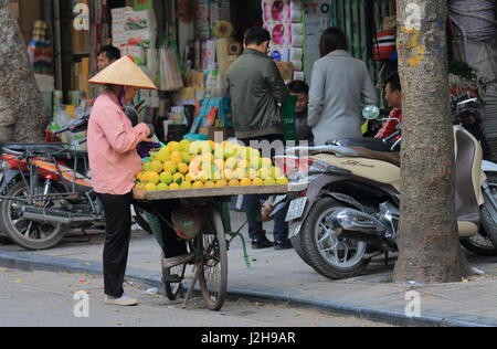 Femme non identifiée vend des oranges dans le vieux quartier de Hanoi au Vietnam. Banque D'Images