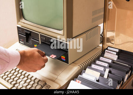 Âgés de Apple Computer et insérez la disquette à l'intérieur de la main Banque D'Images