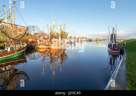 Greetsiel, Allemagne - 6 décembre 2014 : ville touristique de la mer du Nord avec un petit port. Il y a plusieurs bateaux amarrés typique pour la pêche. Banque D'Images