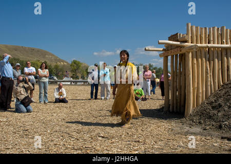 Jeune femme habillé en robe à franges daim traditionnelle présente l'histoire et les modes de vie les Mandan, Hidatsa et Arikara tribus. Le traditionnel village de maisons de terre sur la réserve indienne de Fort Berthold, Dakota du Nord Banque D'Images