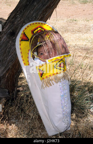 Native American baby avec lacets jusqu'à l'intérieur d'un porte-bébé willow traditionnel décoré de perles jaune coloré Banque D'Images