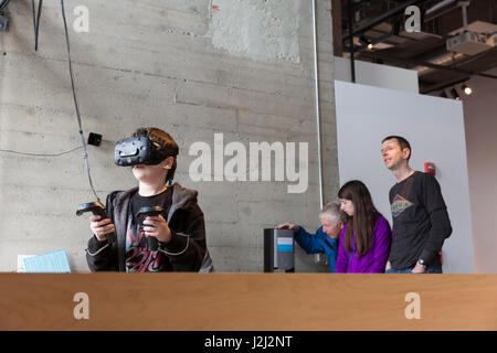 Seattle, Washington : Riche M. regarde son fils Ryan démontrer la casque de réalité virtuelle dans le VR/AR à l'exposition vivant Ordinateurs : Musée  + Labs. Banque D'Images