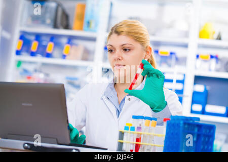 Female scientist holding test tube dans le laboratoire. Banque D'Images