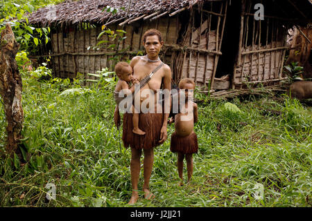 Mère et enfants de la tribu Korowai Forêt Nomade. La Papouasie occidentale, en Indonésie Banque D'Images