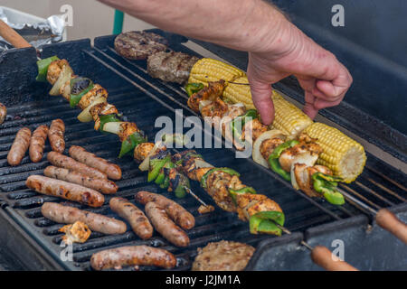La cuisson à la main des hommes un gril de gaz en Angleterre Banque D'Images