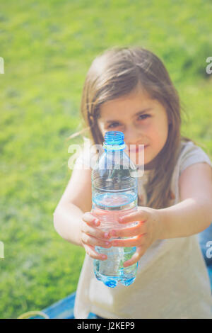 Petite fille est titulaire d'une bouteille d'eau Banque D'Images