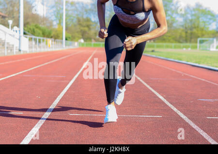L'exécution de jambes musclées d'un jeune athlète de la formation ou l'entraînement sur une piste dans un sport low angle view le long de l'allée Banque D'Images