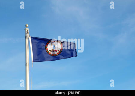 Drapeau du Commonwealth de Virginie à voler d'un pôle alors que contre un ciel bleu et Cirrus nuages de fond Banque D'Images