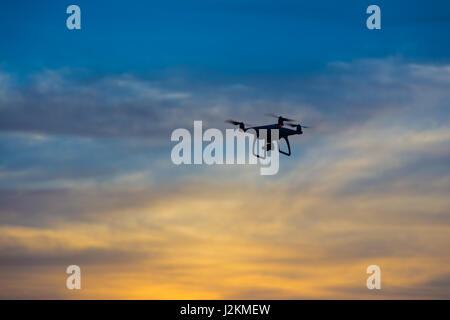 Silhouette d'un drone against colorful sunset sky Banque D'Images